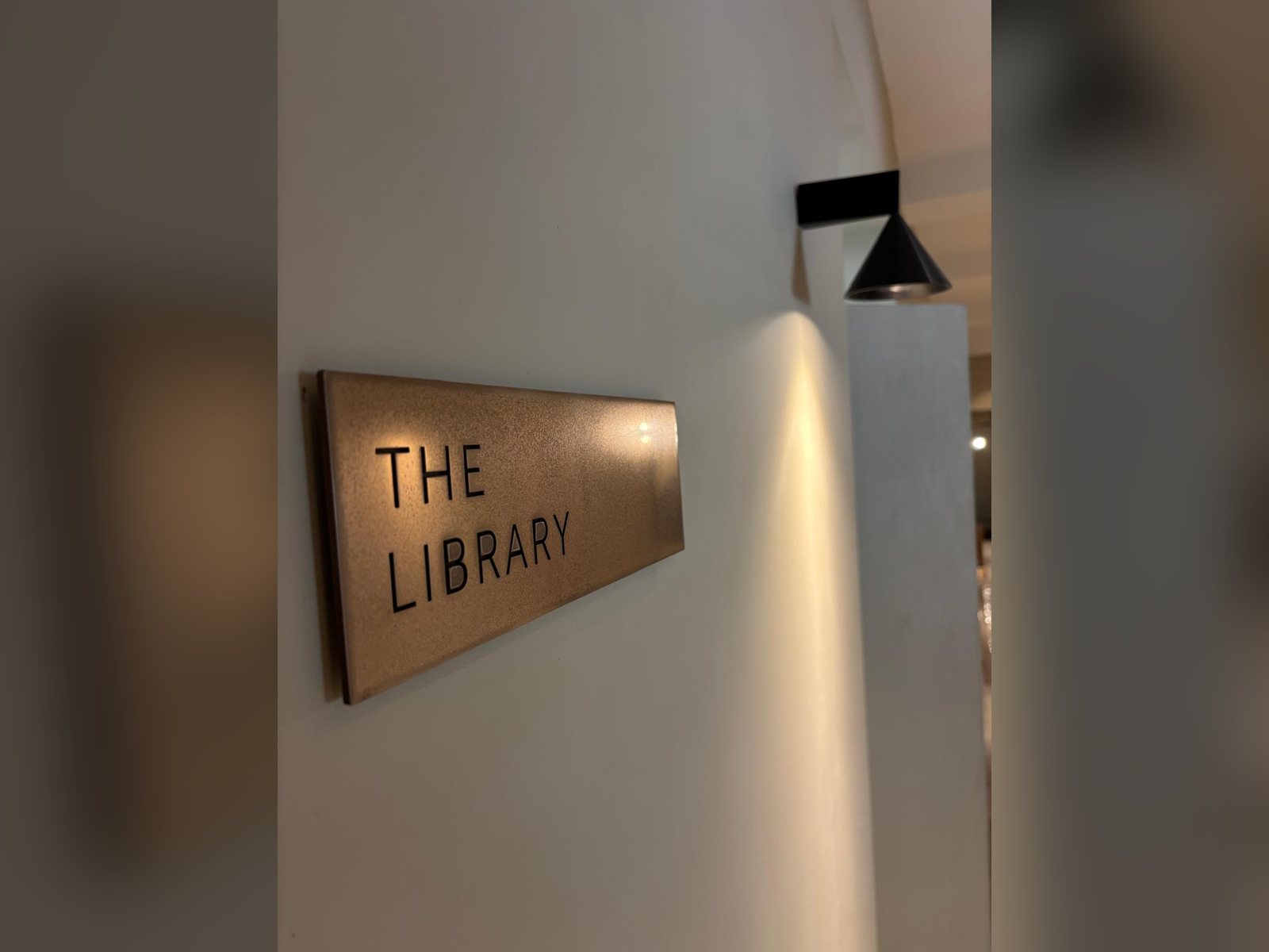 Tactile library door sign with raised lettering in a bronze finish