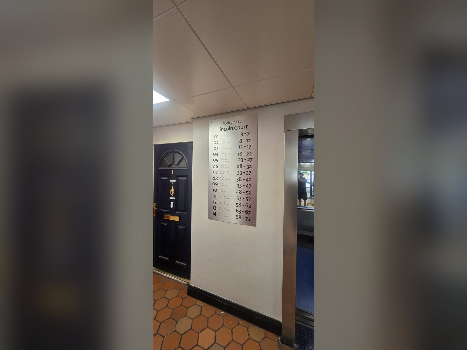 Tactile floor and flat number directory in a residential lobby