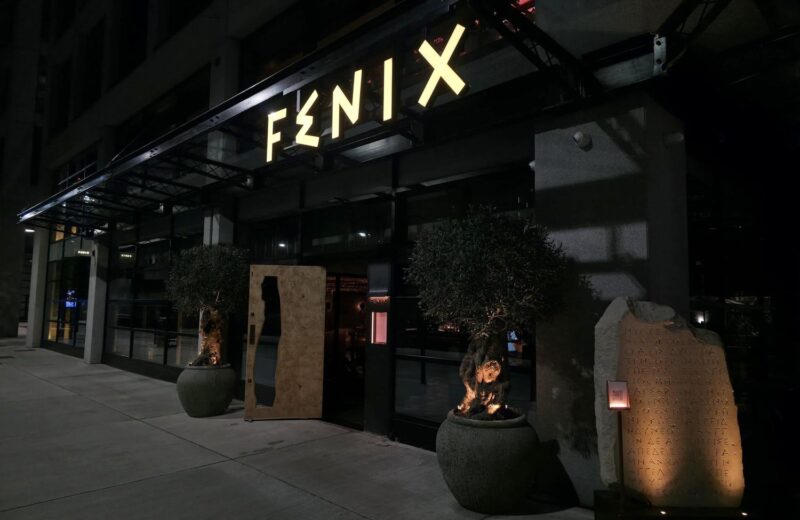 Fenix Manchester illuminated built-up letters lit along the glazed canopy at night