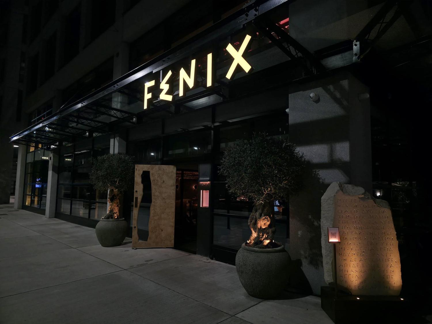 Fenix Manchester illuminated built-up letters lit along the glazed canopy at night