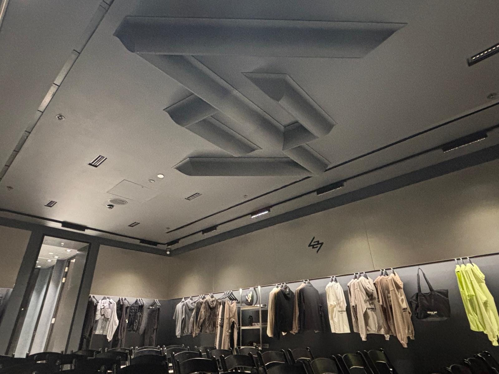 Sculpted 3D logo feature built into a retail store ceiling