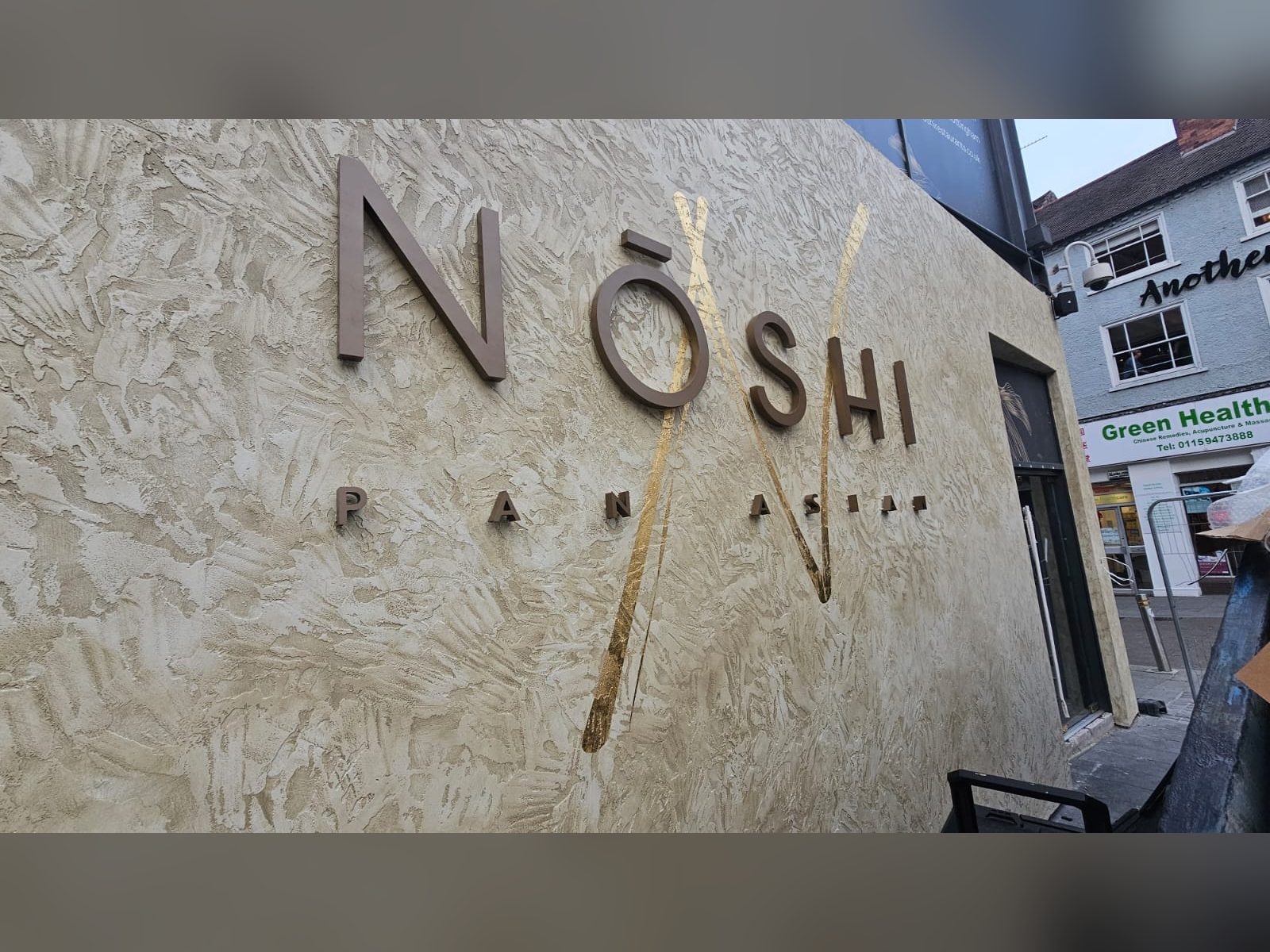 Brushed metal built up letters on a textured restaurant wall