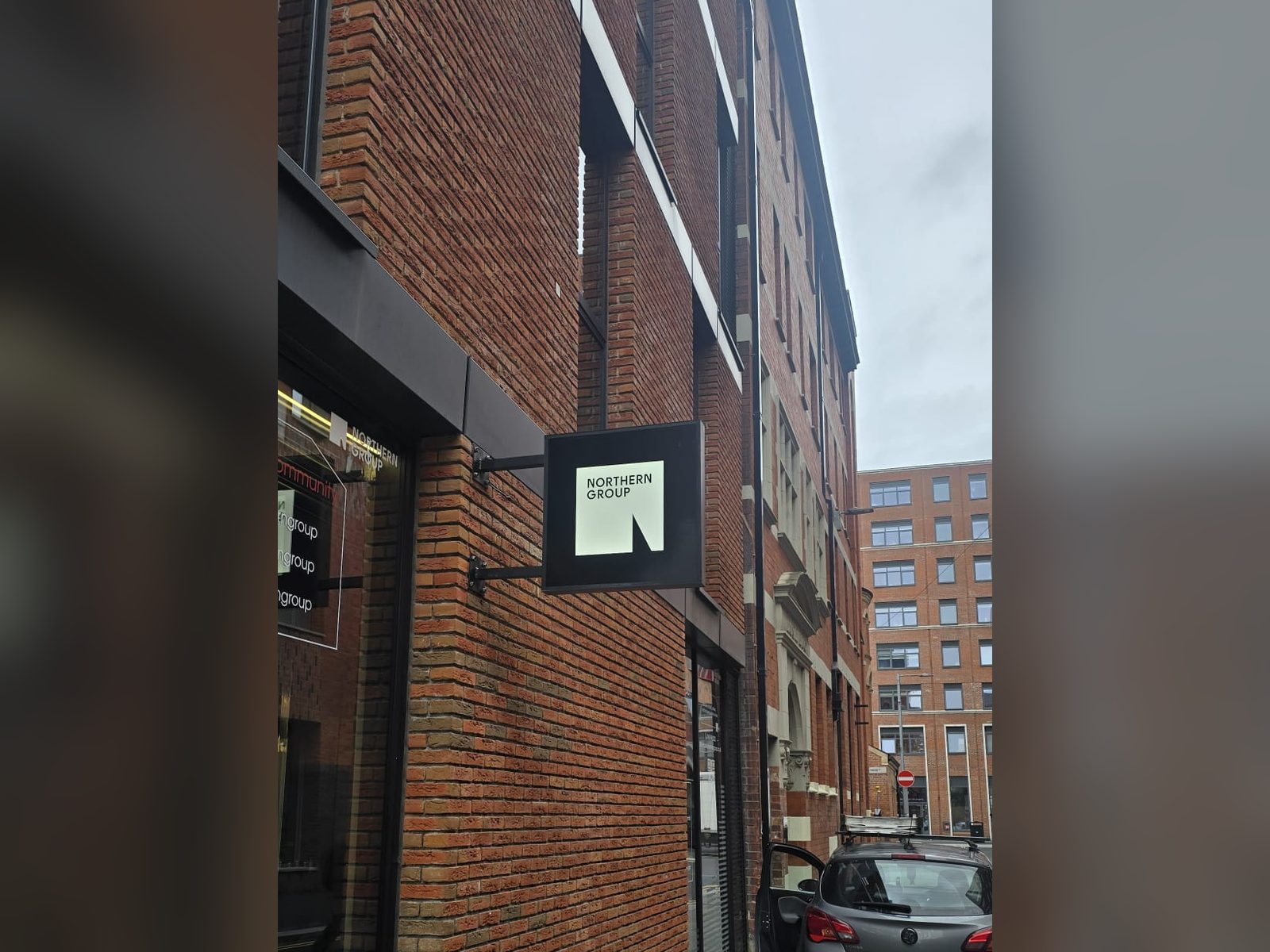 Slim projecting sign on a brick facade