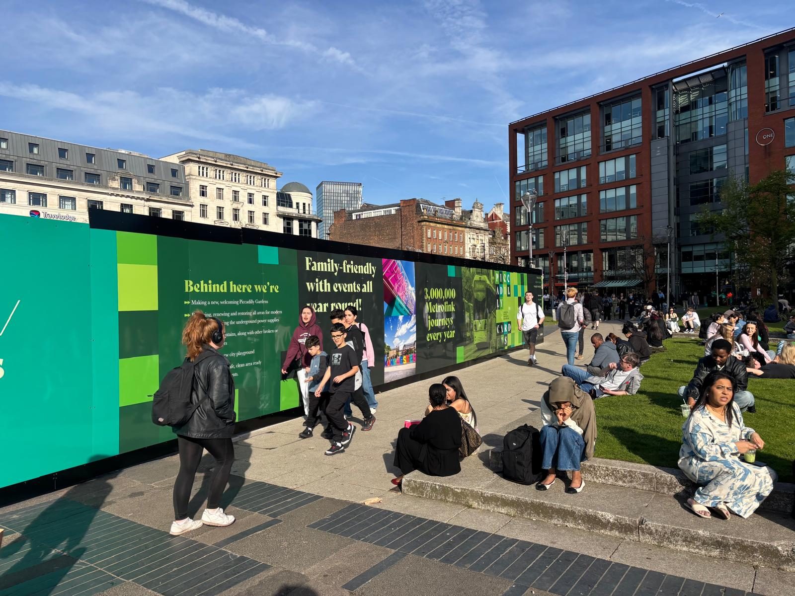 Printed hoarding around Piccadilly Gardens in Manchester city centre