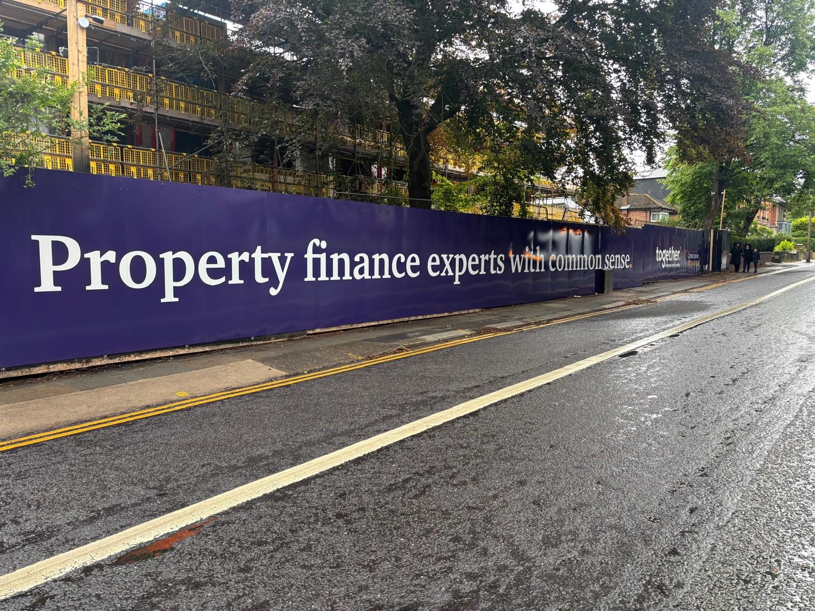 Long printed hoarding along a residential street