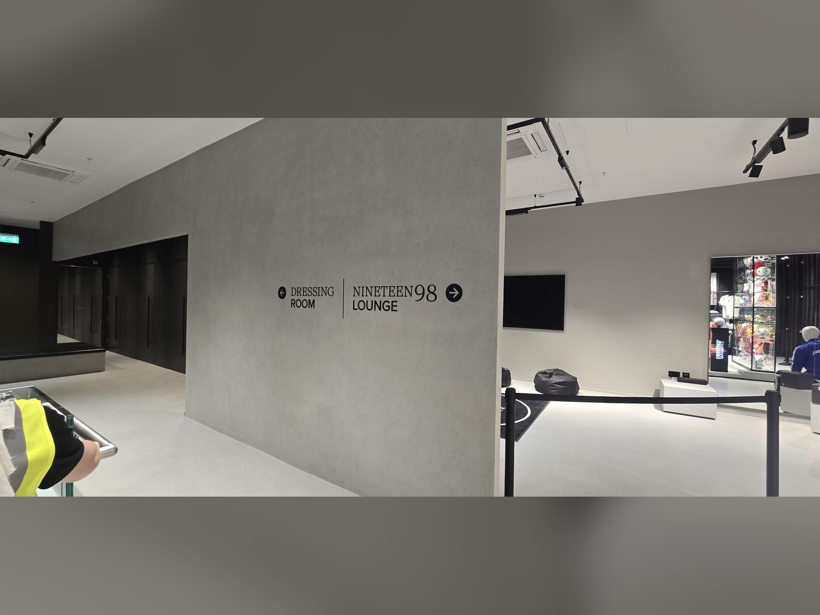 Wayfinding lettering with arrow on a concrete effect wall