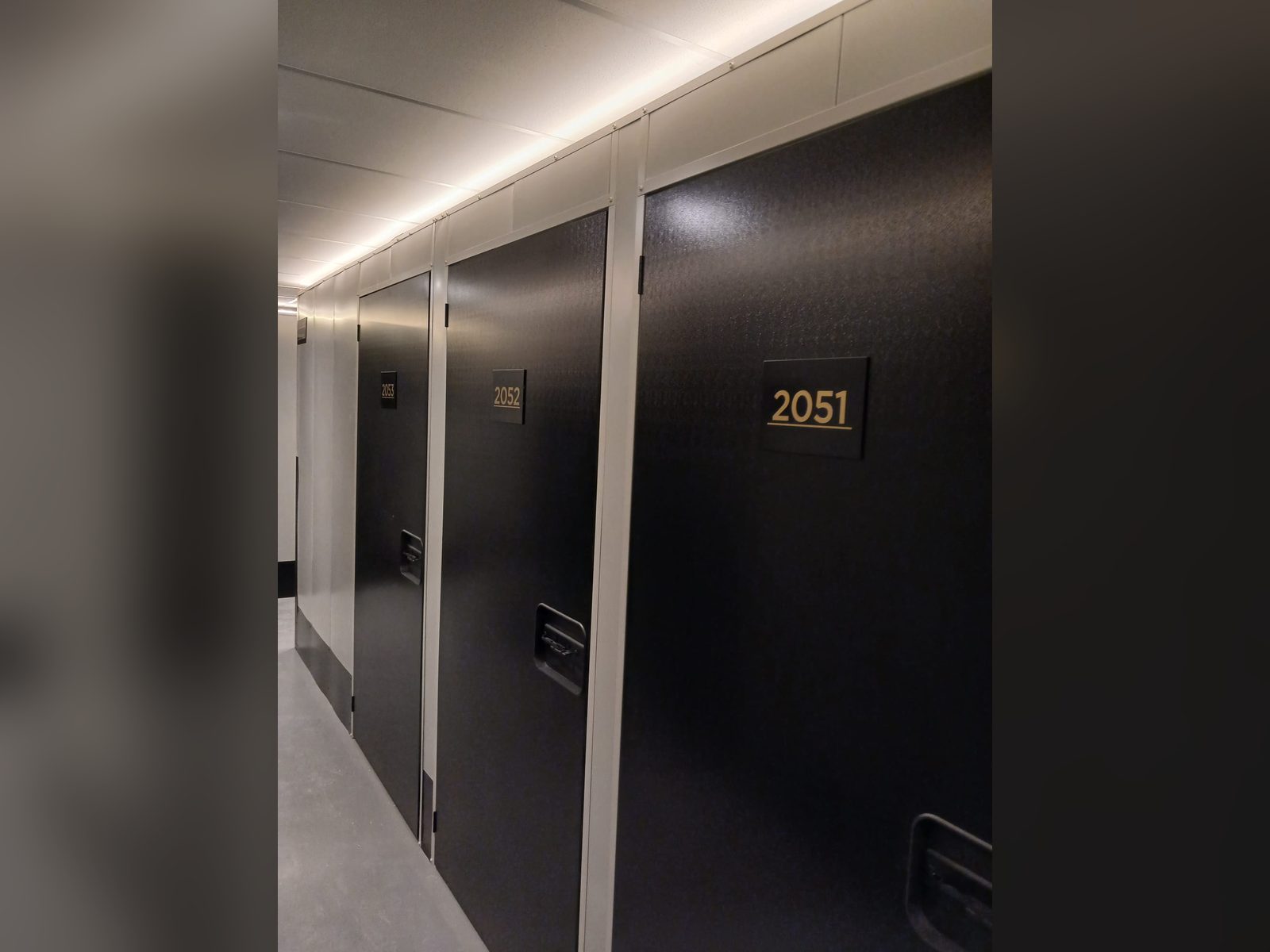 Gold apartment door numbers on black doors
