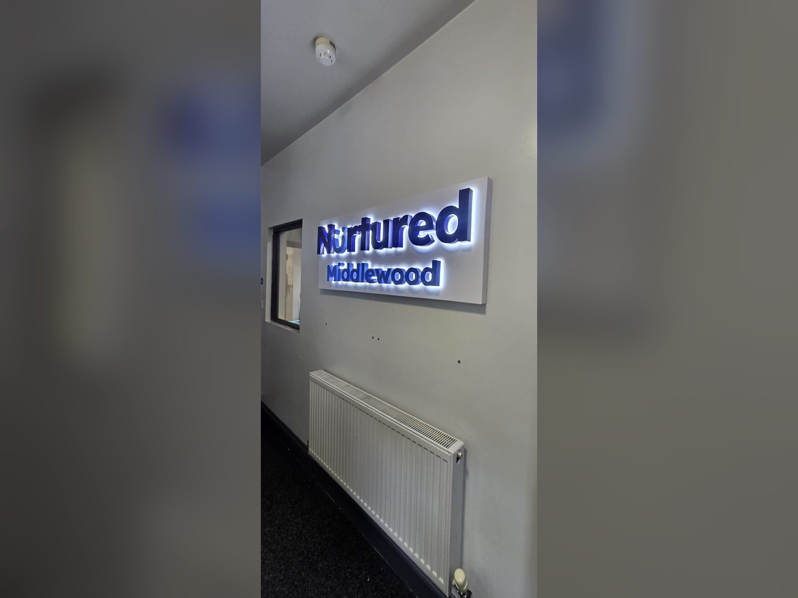 Illuminated wall sign in a nursery corridor