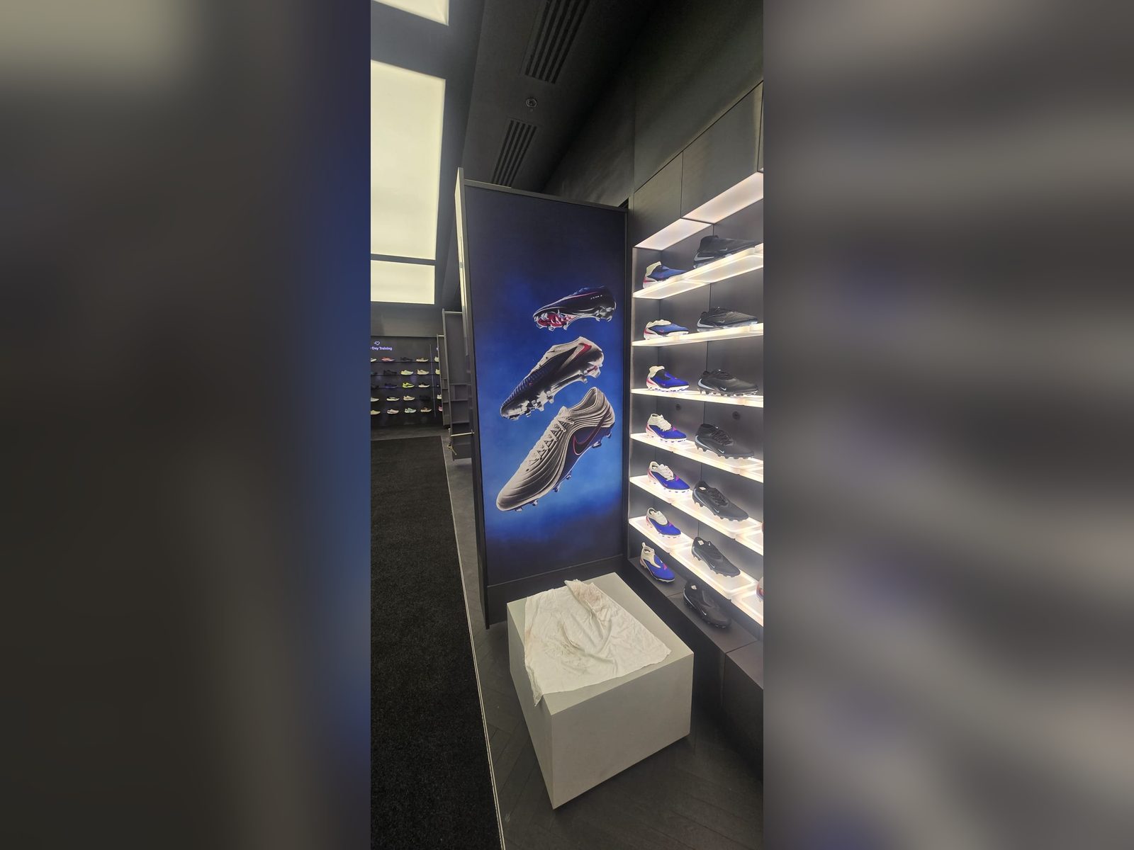 Retail graphic panel beside an illuminated shoe wall