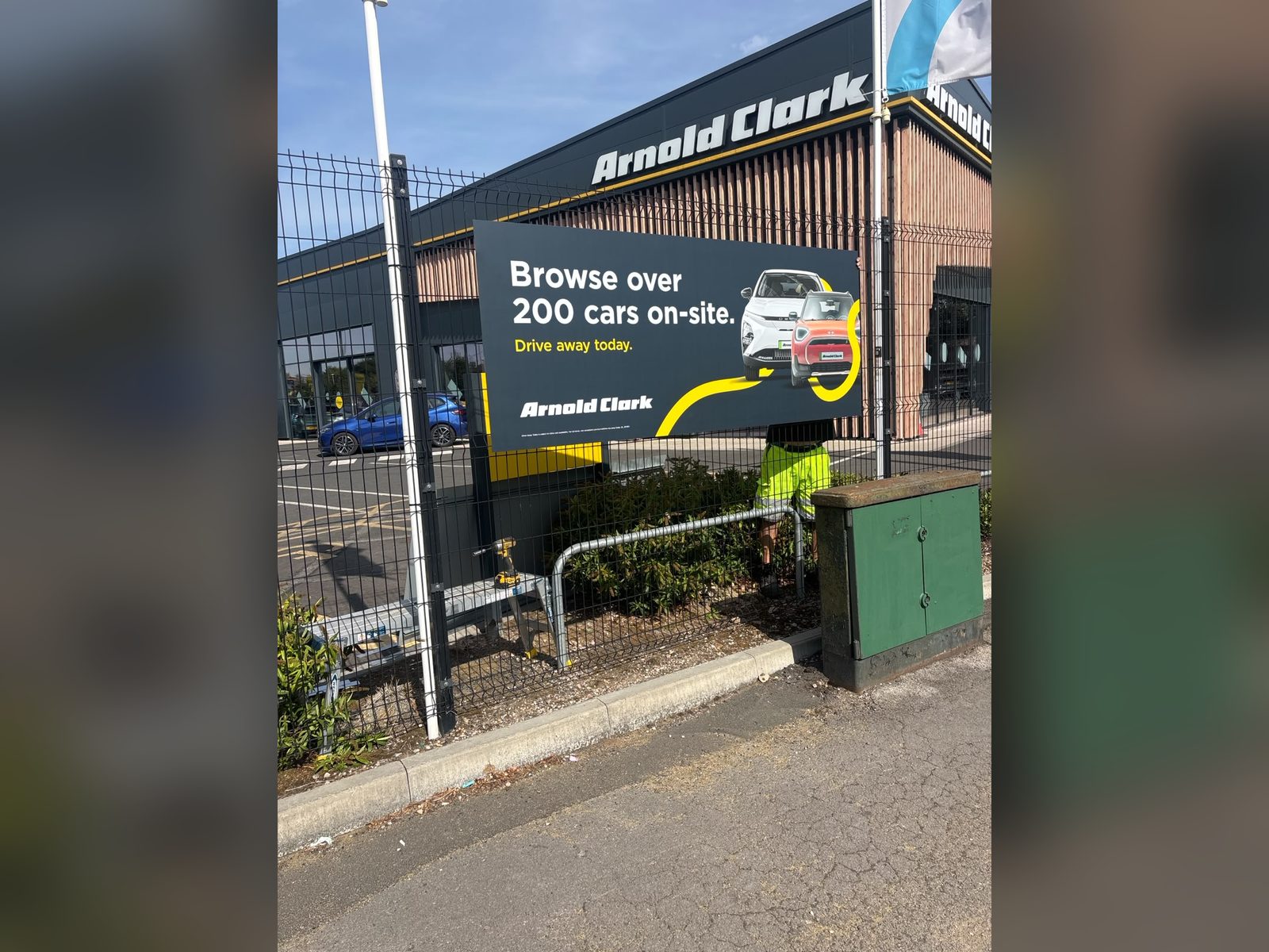 Printed fence banner outside a car dealership