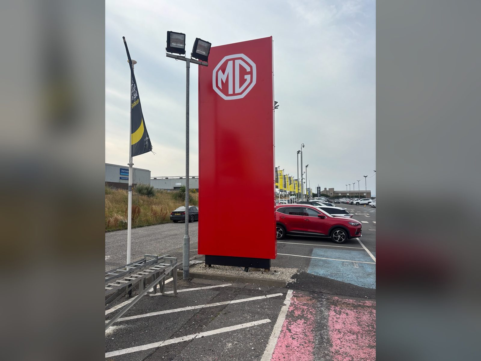 Tall illuminated pylon totem at a car dealership