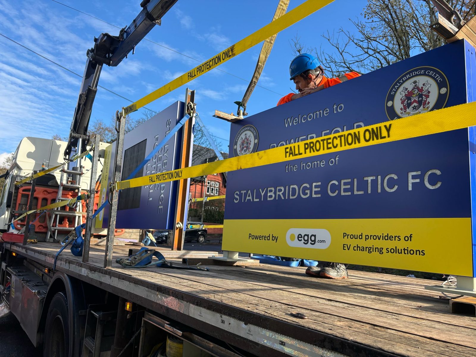 Totem sign being lifted into position by crane during installation