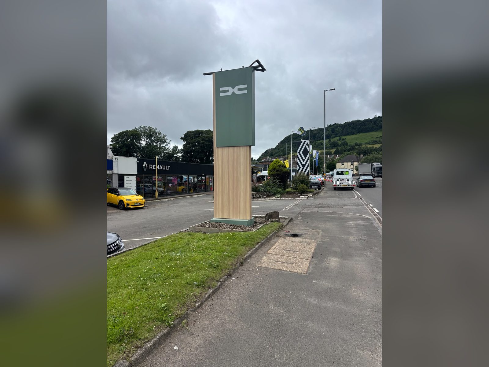 Timber clad totem with brand panel at a dealership