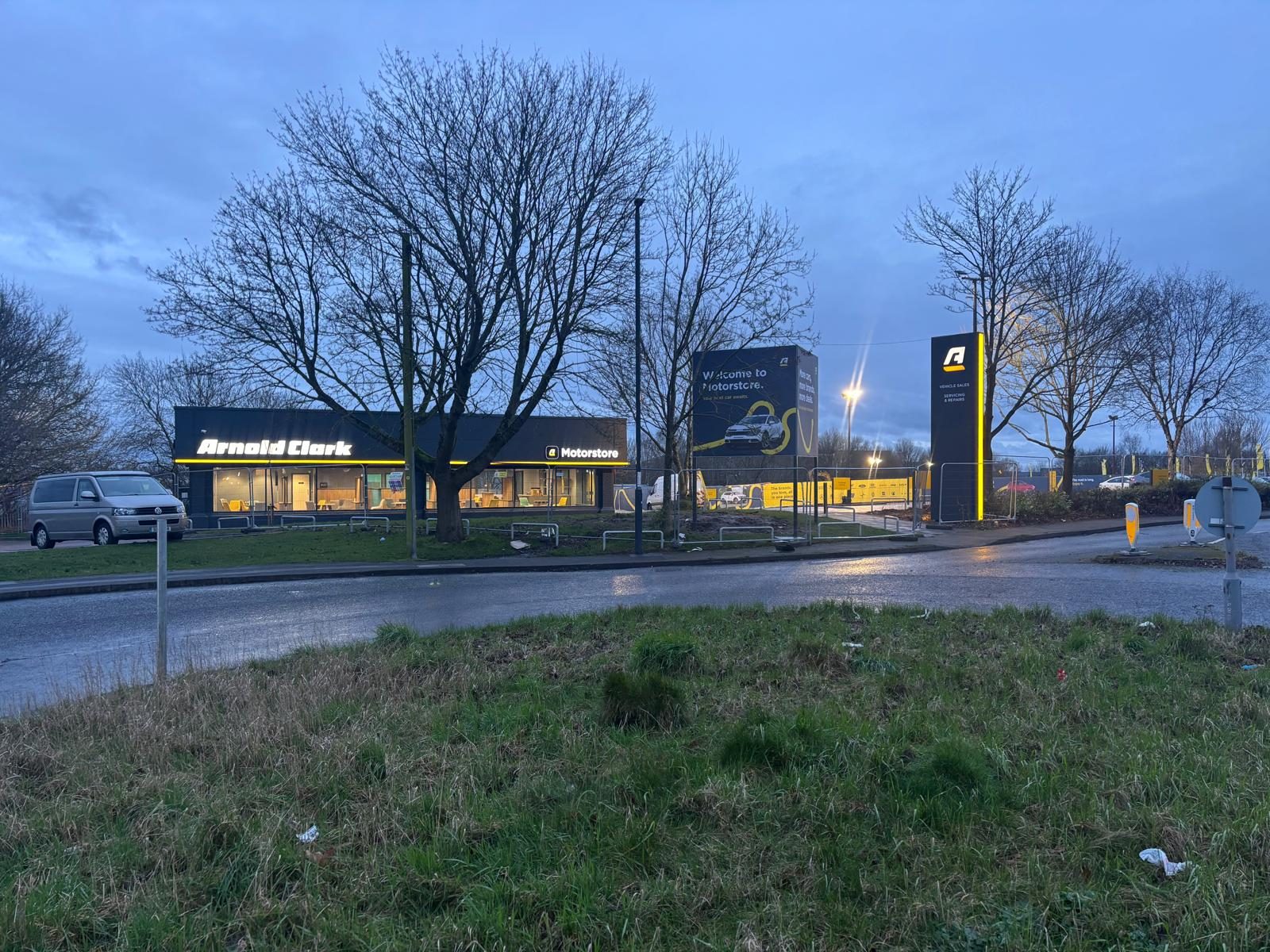 Illuminated dealership totems at dusk