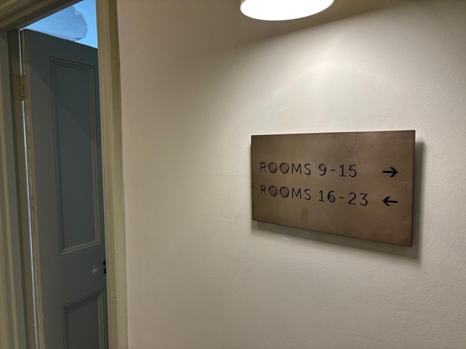 Bronze finish room directional sign in a corridor