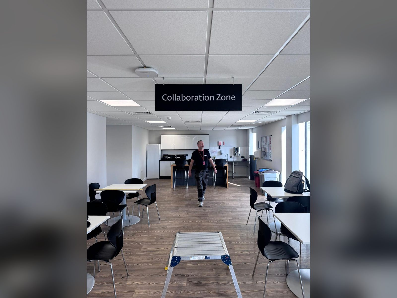 Suspended zone identification sign in an office