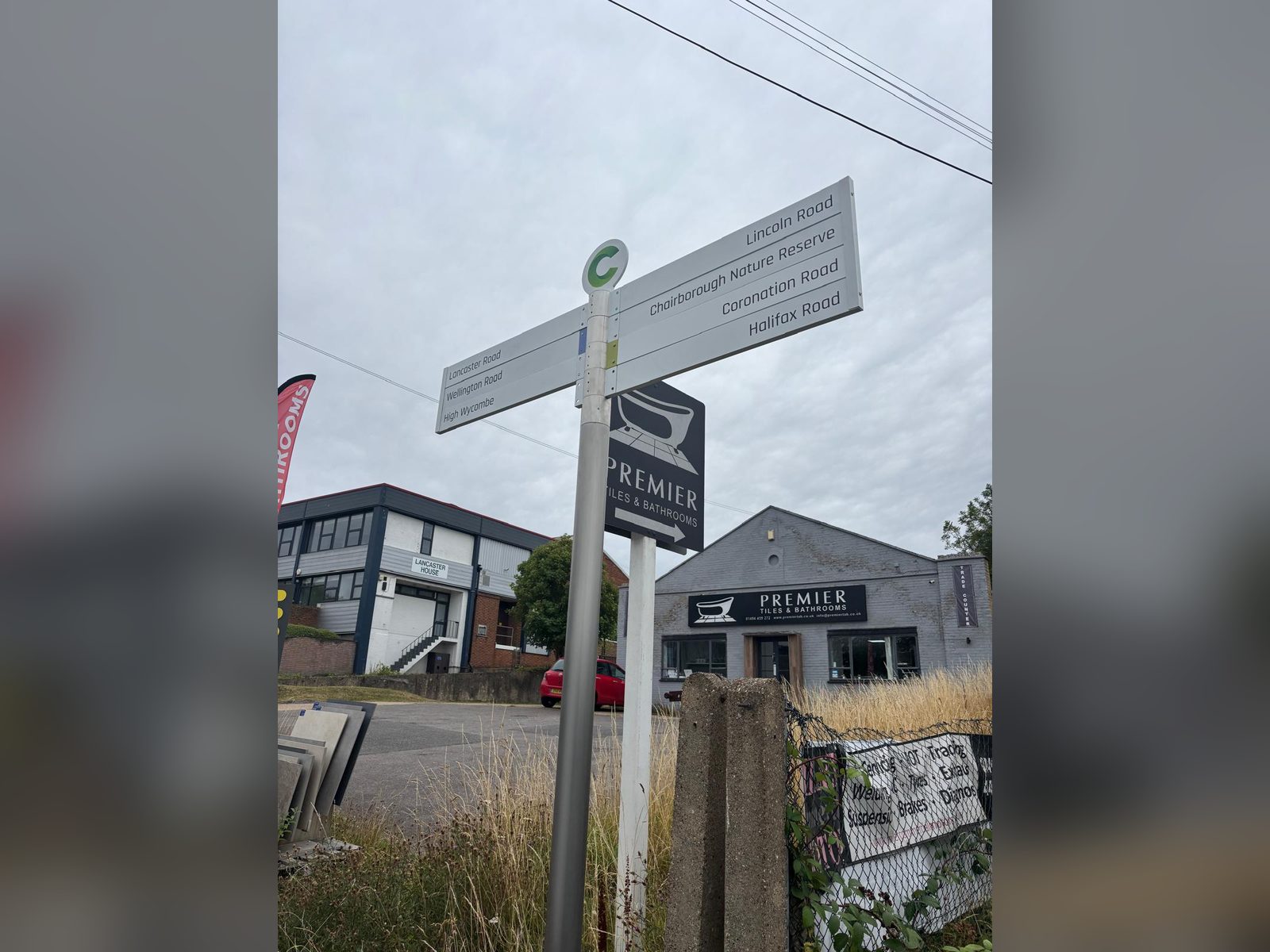 Fingerpost with directional arms beside commercial units