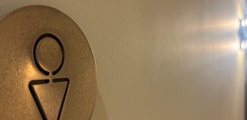 Bronze tactile toilet sign with raised pictogram by SPI, Manchester